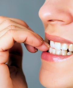 A closeup of a person biting their fingernails