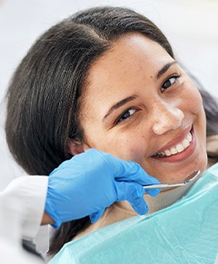 A smiling woman receiving a dental checkup