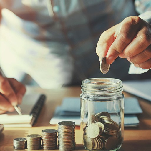 Someone putting coins into a jar