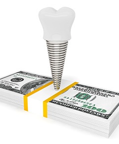 Dental implant on a pile of money