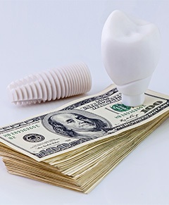 Dental implant parts on a pile of money